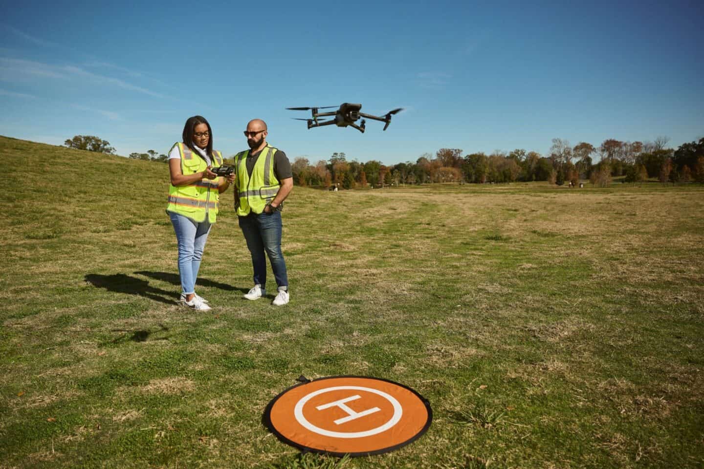 Two people landing a drone